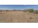 Empty lot with dry grass, construction visible nearby at 24520 W Duane Ln, Wittmann, AZ 85361