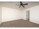 Spacious bedroom with ceiling fan, carpet, and access to bathroom at 24604 W Duane Ln, Wittmann, AZ 85361