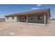 House exterior showcasing a covered patio and desert landscape at 24604 W Duane Ln, Wittmann, AZ 85361