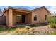 Exterior view of the backyard showing the covered patio, backyard landscaping and sliding glass doors at 2716 W Allens Peak Dr, San Tan Valley, AZ 85144