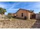 Wide view of the home's backyard with block fence, desert landscaping, and covered patio at 2716 W Allens Peak Dr, San Tan Valley, AZ 85144