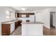Cozy kitchen with brown cabinets, white appliances, and a functional island for meal preparation at 2716 W Allens Peak Dr, San Tan Valley, AZ 85144