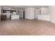 Spacious open-concept living room with kitchen view, neutral tile flooring, and bright white walls at 2716 W Allens Peak Dr, San Tan Valley, AZ 85144