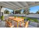 Covered patio with wooden dining set and artificial turf at 285 W San Angelo St, Gilbert, AZ 85233