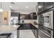 Modern kitchen with dark cabinetry, stainless steel appliances, and granite countertops at 31224 N 26Th Dr, Phoenix, AZ 85085