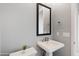 Modern bathroom with pedestal sink and framed mirror at 32978 N 131St Dr, Peoria, AZ 85383