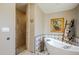 Spa-like bathroom with soaking tub, walk-in shower, and tile flooring at 37202 N Holiday Ln, Carefree, AZ 85377