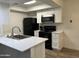 Modern kitchen with white cabinets and black appliances at 520 N Stapley Dr # 290, Mesa, AZ 85203