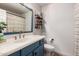Modern bathroom with blue vanity and gold fixtures at 5715 N 105Th Ln, Glendale, AZ 85307