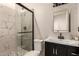 Modern bathroom with marble tile and a glass shower at 5715 N 105Th Ln, Glendale, AZ 85307