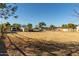 Open land with dry grass and distant structures at 5715 N 105Th Ln, Glendale, AZ 85307