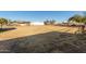 Open land with dry grass and distant structures at 5715 N 105Th Ln, Glendale, AZ 85307