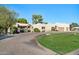 A beautiful stucco home with a large driveway and lush green lawn at 7032 E Dreyfus Ave, Scottsdale, AZ 85254