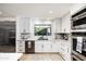Bright kitchen with white cabinets, stainless steel appliances, and a large window at 7032 E Dreyfus Ave, Scottsdale, AZ 85254