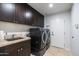 Bright laundry room with washer, dryer, cabinets, and utility sink at 7032 E Dreyfus Ave, Scottsdale, AZ 85254