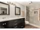 Modern bathroom with double vanity, shower, and dark wood cabinets at 10814 W Thunderbird Blvd, Sun City, AZ 85351