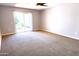 Spacious carpeted bedroom with sliding glass door leading to backyard at 10814 W Thunderbird Blvd, Sun City, AZ 85351