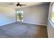 Spacious carpeted bedroom with ceiling fan and large windows at 10814 W Thunderbird Blvd, Sun City, AZ 85351