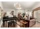 Elegant living room with piano, leather furniture, and chandelier at 10814 W Thunderbird Blvd, Sun City, AZ 85351