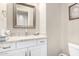 White vanity with granite countertop, sink, and mirror in a well-lit bathroom at 10855 E Elba Way, Scottsdale, AZ 85262