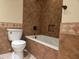 This bathroom has a shower-tub combo, a toilet, and brown tiled walls at 1410 E Bishop Dr, Tempe, AZ 85282