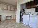 Functional laundry room with built-in cabinets, a desk area, and a water heater at 1410 E Bishop Dr, Tempe, AZ 85282