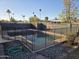 Backyard pool featuring surrounding rock landscape, black fence, hose and basketball hoop at 1410 E Bishop Dr, Tempe, AZ 85282