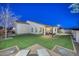 Backyard view at night with covered patio and lounge chairs at 16871 W Cielo Grande Ave, Surprise, AZ 85387