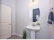 Stylish bathroom with pedestal sink, oval mirror and grey tile floor at 16871 W Cielo Grande Ave, Surprise, AZ 85387