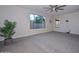 Bright bedroom with grey carpet, large window, and ceiling fan at 16871 W Cielo Grande Ave, Surprise, AZ 85387