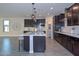 Island kitchen with dark cabinetry, white backsplash, and stainless steel appliances at 16871 W Cielo Grande Ave, Surprise, AZ 85387