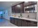 Kitchen with dark cabinets, quartz countertops and herringbone backsplash at 16871 W Cielo Grande Ave, Surprise, AZ 85387