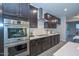 Modern kitchen with double oven, gas cooktop, and dark wood cabinetry at 16871 W Cielo Grande Ave, Surprise, AZ 85387