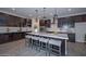 Spacious kitchen boasts a large island, white herringbone backsplash, and dark cabinetry at 16871 W Cielo Grande Ave, Surprise, AZ 85387