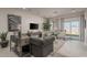 Living room with dark gray sofa and sliding glass doors to backyard at 17058 W Seldon Ln, Waddell, AZ 85355