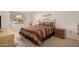 Bedroom with striped bedding, dresser, and window with curtains at 18014 N Broken Bow Ct, Sun City, AZ 85373