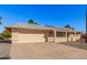 Tan one-story house with a red door, two-car garage, and desert landscaping at 18014 N Broken Bow Ct, Sun City, AZ 85373