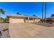 Tan one-story house with a red door, two-car garage, and desert landscaping at 18014 N Broken Bow Ct, Sun City, AZ 85373