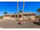 Tan one-story house with a red door, two-car garage, and desert landscaping at 18014 N Broken Bow Ct, Sun City, AZ 85373