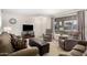 Living room with neutral colored couches, chairs, and a large window at 18014 N Broken Bow Ct, Sun City, AZ 85373