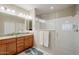 Double vanity bathroom with a large walk-in shower and granite countertops at 18055 W Muirwood Dr, Goodyear, AZ 85338