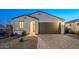 Single-story home with brown garage door and landscaped front yard at 18055 W Muirwood Dr, Goodyear, AZ 85338