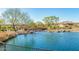 Lake with a wooden footbridge and lush landscaping at 18055 W Muirwood Dr, Goodyear, AZ 85338