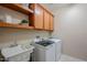 Laundry room with washer, dryer, cabinets, and a utility sink at 18055 W Muirwood Dr, Goodyear, AZ 85338