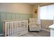 Bedroom with crib, recliner, and decorative wall paneling at 1860 S 24Th St, Mesa, AZ 85204