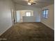 Living room with tile and carpet flooring, and access to dining area at 19002 N Toledo Ave, Maricopa, AZ 85138