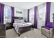 Cozy bedroom with a dark wood bed frame and purple accents at 21002 E Mayberry Rd, Queen Creek, AZ 85142