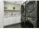 Laundry room with white cabinets and a stackable washer and dryer at 2246 E Bethany Home Rd, Phoenix, AZ 85016