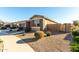 View of home's side elevation, showing stone accents and a gated side yard at 22643 E Stonecrest Dr, Queen Creek, AZ 85142