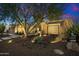 Night view of a single-story home with well-maintained landscaping and lighting at 2423 E Marshall Ave, Phoenix, AZ 85016